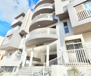 a building with white balconies and stairs in front of it at The Papillon Penthouse in Santa Vennera