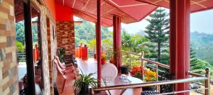 a balcony of a house with a table and chairs at Holidayincoorg Royal Mansion in Madikeri