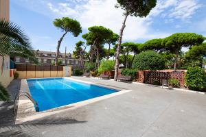 una piscina en un patio con árboles en White Sea by Seasidehomes en Castelldefels