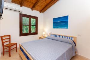 een slaapkamer met een bed, een stoel en een raam bij Casa Teodoro in San Teodoro