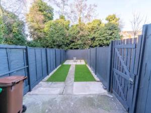 a yard with a blue fence and grass at Pass the Keys Elegant Home with free Parking in Nottingham