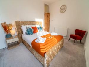 um quarto com uma cama e uma cadeira vermelha em Pass the Keys Elegant Home with free Parking em Nottingham