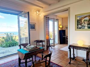 a living room with a view of the ocean at Les Tamaris **** YourHostHelper in Omonville-la-Rogue