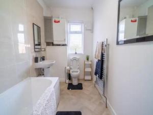 a bathroom with a tub and a toilet and a sink at Pass the Keys Elegant Home with free Parking in Nottingham