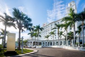 a large white building with palm trees in front of it at Riu Palace Pacifico - All Inclusive - Adults Only in Nuevo Vallarta
