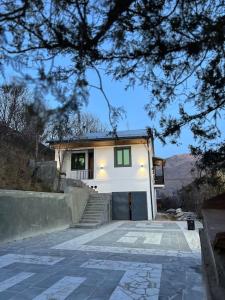 een klein wit huis met een trap ervoor bij Regana Guest House Aghveran in Arzakan