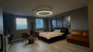 a bedroom with a bed and a couch at VitaLounge Sports & Spa Hotel in Gelsenkirchen +22 photos
