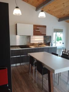 eine Küche mit einem weißen Tisch und schwarzen Stühlen in der Unterkunft Casa Chélo in Saint-Vincent-de-Tyrosse