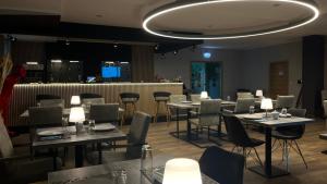 una sala da pranzo con tavoli, sedie e luci di VitaLounge Sports & Spa Hotel a Gelsenkirchen