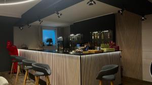 een bar met een rij krukken in een kamer bij VitaLounge Sports & Spa Hotel in Gelsenkirchen