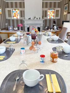 a table with plates and bowls on top of it at Chambres d'hôtes La Mansardière in Cancale