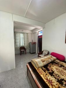 1 dormitorio con 1 cama grande y 1 silla en Shrubbery Homestay and Guest house, en Darjeeling
