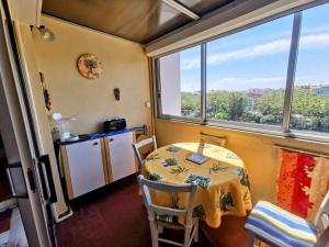 a small kitchen with a table and a window at 001 Sentosa A15 in Cap d'Agde