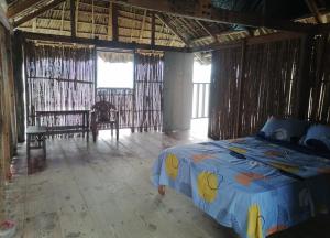 ein Schlafzimmer mit einem Bett in einem Zimmer mit Fenstern in der Unterkunft Isla narasgandub cabaña en tierra in Nusatupo