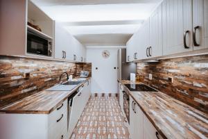 a kitchen with white cabinets and a brick wall at Lichkovská chalupa in Lichkov