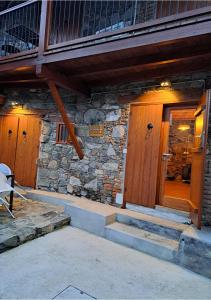a stone house with wooden doors and stairs at To Apokentro in Alona