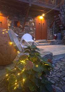 une chaise blanche assise devant une maison avec une plante dans l'établissement To Apokentro, à Alona