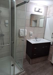 a bathroom with a glass shower and a sink at To Apokentro in Alona