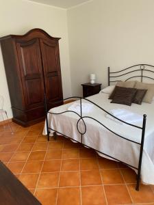1 dormitorio con 1 cama y armario de madera en Baglio Quadrone Torre Salsa, en Montallegro