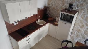 a small kitchen with a sink and a microwave at Apartment Tia Vis in Vis