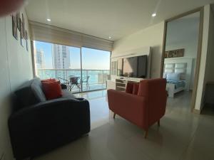 - un salon avec deux chaises, un lit et une télévision dans l'établissement Apartamento piso 26, à Carthagène des Indes