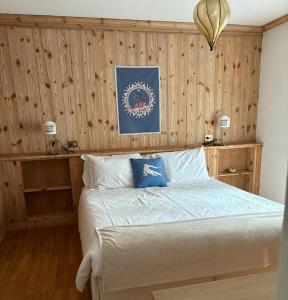 a bedroom with a bed with a wooden wall at APPARTAMENTO CORTINA 1956 in Cortina dʼAmpezzo