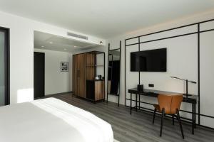 a bedroom with a bed and a desk and a television at Radisson Hotel Tunis, City Center in Tunis