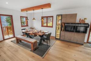 a dining room with a table and a kitchen at Charmant et spacieux chalet moderne in Cergnat