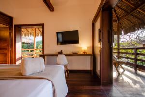 a bedroom with a bed and a tv and a balcony at Villa Messina Jeri in Jericoacoara