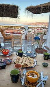 una mesa con platos de comida con vistas en Paddle Out Morocco en Tamraght Ouzdar