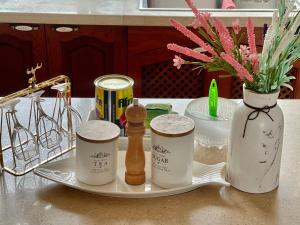 a tray with medicines and a vase with flowers on a counter at Arrabella Ocean View Home in Dar es Salaam