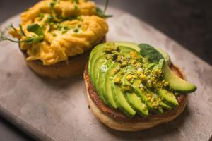 dos trozos de pan con aguacate y otros ingredientes. en Vitoria Stone Hotel, en Évora