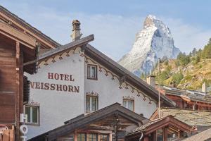 un hotel con una montaña en el fondo en Hotel Weisshorn, en Zermatt