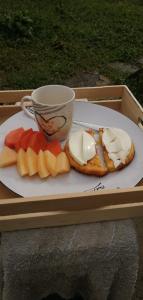 a plate of food with cheese and fruit and a cup at Habitación en casa Rural Campestre in La Vega