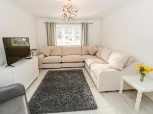 sala de estar con sofá blanco y TV en Serenity en Freshwater