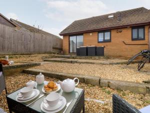 a table with a tea set on it in a backyard at Serenity in Freshwater