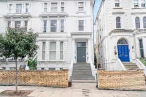 Biały dom z niebieskimi drzwiami i schodami w obiekcie Be London - Maida Vale Residences w Londynie
