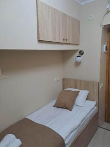 a bedroom with a bed with white sheets and a cabinet at Apartment on Xancteli in Tbilisi City