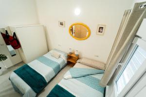 2 camas en una habitación pequeña con espejo en Precioso Loft cerca Málaga-Centro, La princesa, en Málaga