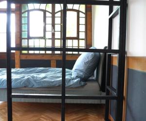 ein schwarzes Etagenbett in einem Zimmer mit Fenstern in der Unterkunft Historisches Haus am Triller in Saarbrücken