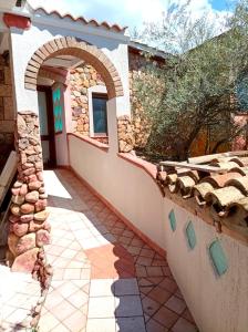 una casa con arco e muro di pietra di House with sea view Sardinia a Solanas