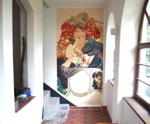 ein Wandbild an der Wand eines Zimmers mit einer Frau, die isst in der Unterkunft Historisches Haus am Triller in Saarbrücken