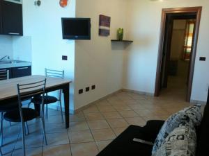 un soggiorno con tavolo e sedie e una cucina di Casa Vacanza Sardegna a Valledoria