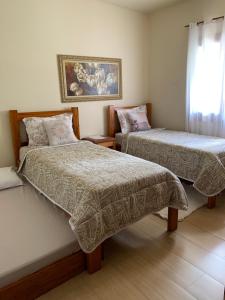 a bedroom with two beds and a window at Casa Encanto das Marés in Paraty