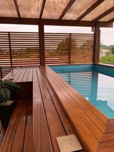 a wooden bench on a deck with a view of the water at Casa Encanto das Marés in Paraty