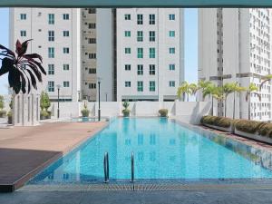 een groot zwembad met gebouwen op de achtergrond bij Harmony suites 1, 3-5 pax, Jelutong Georgetown Penang in Jelutong