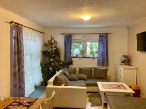 a living room with a couch and a christmas tree at Chalupa ve Sněžném in Sněžné