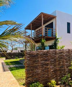 une maison avec une clôture devant elle dans l'établissement Mangal Beach Lodge, à Vilanculos