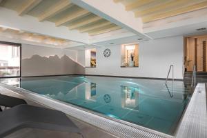 a swimming pool in a building with at Hotel Alpina - Thermenhotels Gastein in Bad Hofgastein
