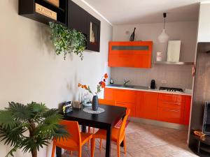 a kitchen with orange cabinets and a table with orange chairs at "CASA ADELIKA" Appartamento con GARAGE sulla via per il MARE in Grosseto